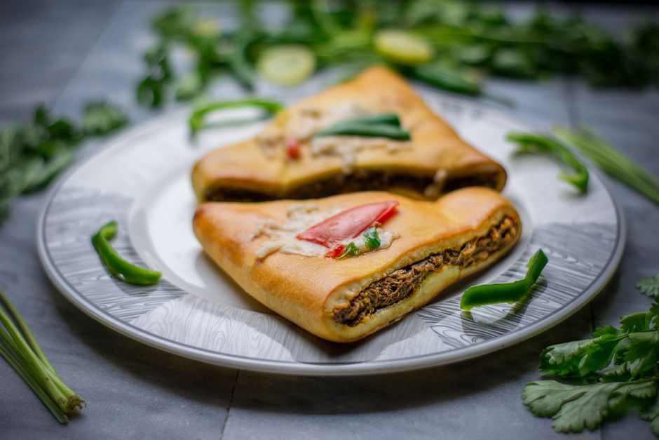 Calzones — Pizza dough folded over cheese and fillings, then baked sealed.