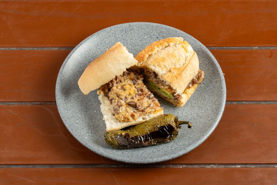 Philly Cheesesteak — Griddled sliced beef and melted cheese in a long roll.