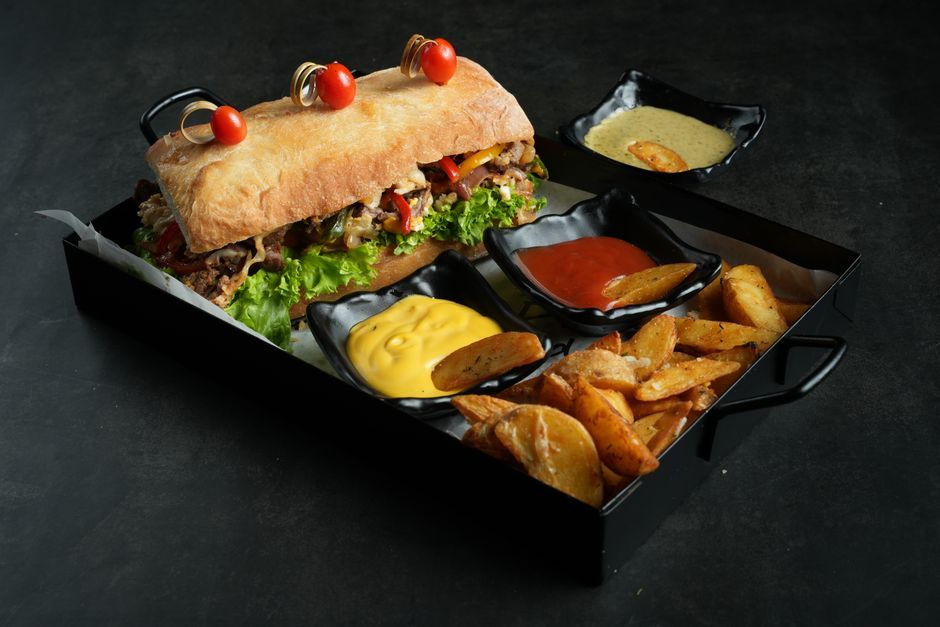Cheesesteak — Griddled sliced beef and melted cheese in a long roll.
