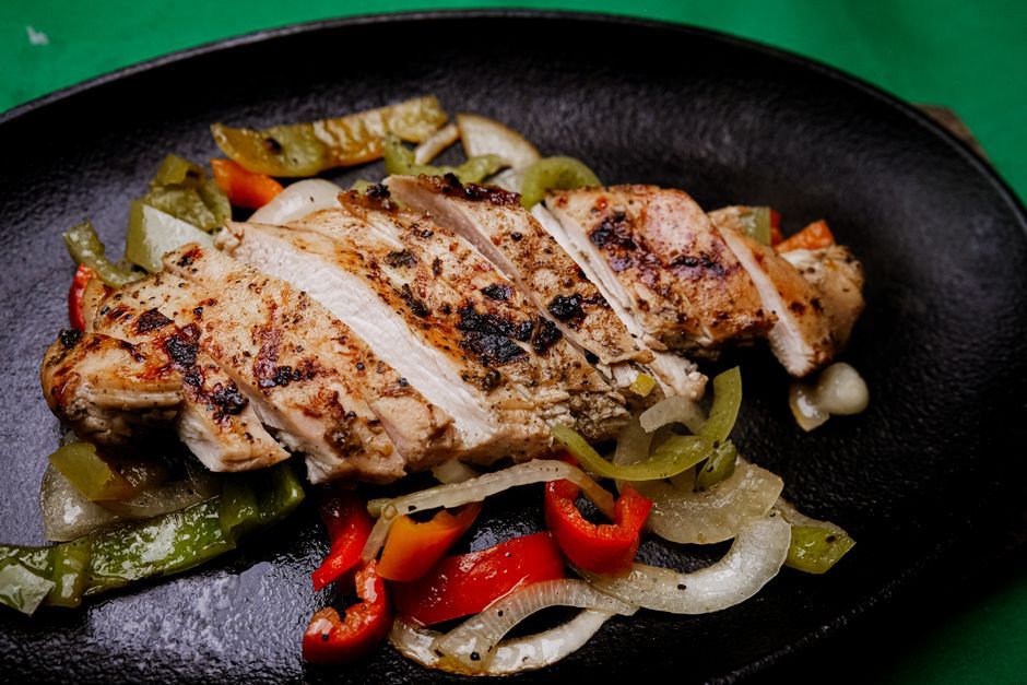 Fajitas — Grilled strips of meat and peppers, served to assemble at the table.