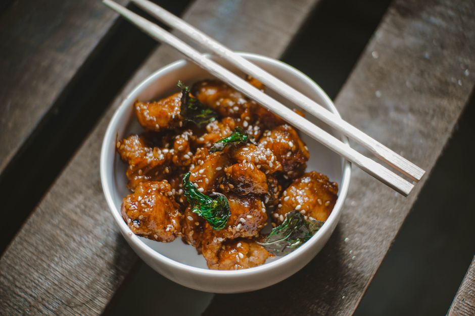 Sesame Chicken — Fried chicken glazed in a sweet soy sauce, finished with sesame seeds.